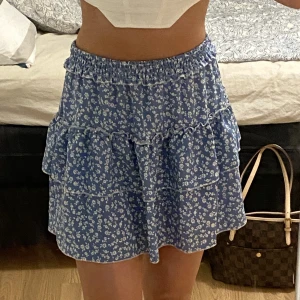 Blå volangkjol - Jättefin blå blommig volangkjol som inte kommer till användning, har resårband inuti och man man även vika ner kanten om önskas! Passar storlek S/M skulle jag säga🥰🫶🏼