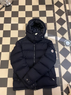 Moncler jacka  - Moncler Montgenevre size 1. Skick 8/10 . 3 pytte små hål på insidan som man knappt ser. Läcker inga fjädrar. Nypris 15.500kr. Endast jacka medföljer . Därav de låga priset . Sms för bilder på QR - kod, labeltag och industri-tag. Jackan är i fint skick.