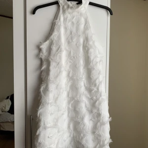 Vit klänning med fjädrar   - Vit klänning med fjädrar som passar perfekt till studenten! Figursydd men sitter ändå löst och fint på. Köpt från bikbok 💕
