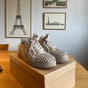 Louboutin Beige Sneaker  - Säljer mina beiga louboutin skor, ovanlig colorway perfekt inför våren! Storlek 41.5 (Sitter som 42-42.5 ungefär, passar mig som har 42.5 i Airforces) | Låda och tillbehör medföljer, skosnören, extranitar och dustbags. Använda men i väldigt bra skick, avgör själv enligt bilderna. | Nypris cirka 8900kr | Finns i Uppsala men hade även kunnat lämna i Stockholm. Kan även frakta men köpare står för fraktkostnad. Skriv vid frågor eller funderingar!