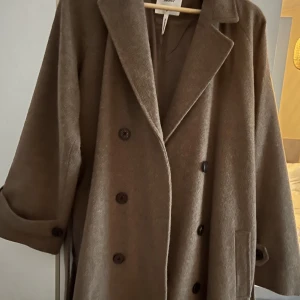 Kappa från Nelly  - Säljer denna super fina kappan från Nelly i storlek 40 (fossil melange). Köptes för 1099kr men säljer för 550 kr eller bud, kappan är endast använd en gång, så den är i princip som ny! ☺️