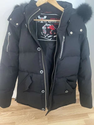 Mosse knukels  - De är en mosse knukels jacka  Storlek M helt svart jacka o svart päls jackan är o använd de finns kvitto på den 