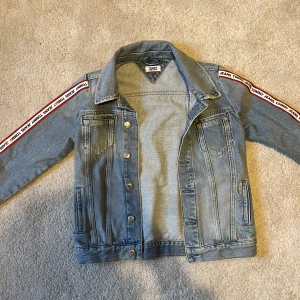 Tommy jeansjacka  - Jeansjacka från Tommy jeans i strl S i en blå-blå färg. Denna jacka har aldrig blivit använd tyvärr då jag har andra, men den sälj inte längre vad jag kan se och är en ovanlig modell. Ganska slim fit strl (inte en oversized fit) och värd ca 1400kr. 