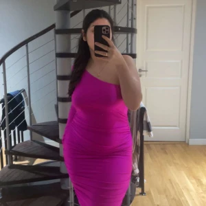 Klänning  - Rosa klänning med en ärm. Lång och tunt material. 