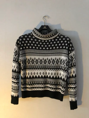Stickad tröja - Svart-vit mönstrad stickad tröja med bred krage. Köpt second hand men är i gott skick kände att den var lite för liten för mig och det är därför jag säljer den💗