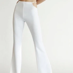 Y2k utsvängda byxor Bershka - Världens snyggaste vita byxor med cut outs vid höfterna från Bershka i storlek L. Endast provade då de var för långa på mig (är 1,62) så helt nya. Frakt 81kr