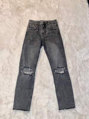 Gråa jeans, ganska raka i modellen med hål på knäna (St 34) #gina