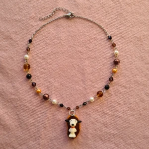 Snoopy/Snobben halsband  - Handgjort halsband. Gjort av rostfritt stål och diverse pärlor💕 Längd är ca 36,8cm långt med 5,5cm extra längd! Är du intresserad men vill ändra något (tex färg på pärlor eller längd) så kan vi fixa det 🥰 Köper du med swish får du gratis frakt! :) 