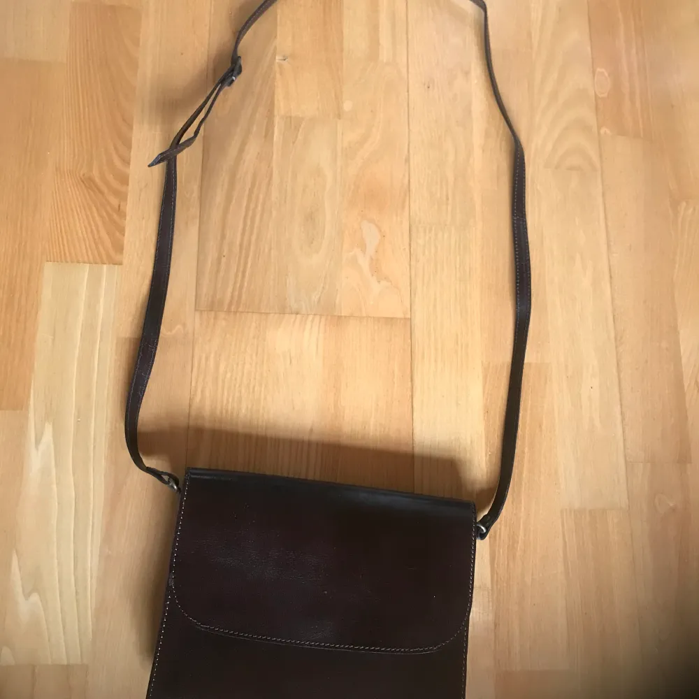 Brun läderväska handväska med många fack. Obetydligt använd, som ny! Reglerbar axelrem. En magnet knäppning framtill och Dragkedje fack baktill. Ett fack inuti. Ren och fräsch och hel. . Väskor.
