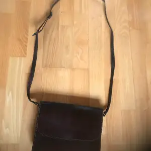 Brun läderväska handväska med många fack. Obetydligt använd, som ny! Reglerbar axelrem. En magnet knäppning framtill och Dragkedje fack baktill. Ett fack inuti. Ren och fräsch och hel. 