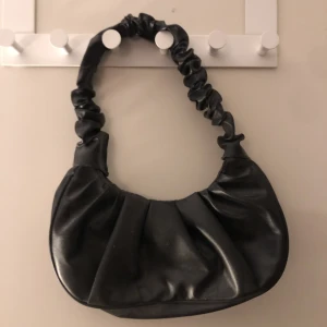 Svart liten väska  - En svart liten väska som bara är använd en gång ❤️ den stängs med en knapp i mitten o ingen dragkedja. Köparen står för frakt men kan även mötas upp❤️ har ni frågor eller vi ha fler bilder så är det bara att skriva 💕