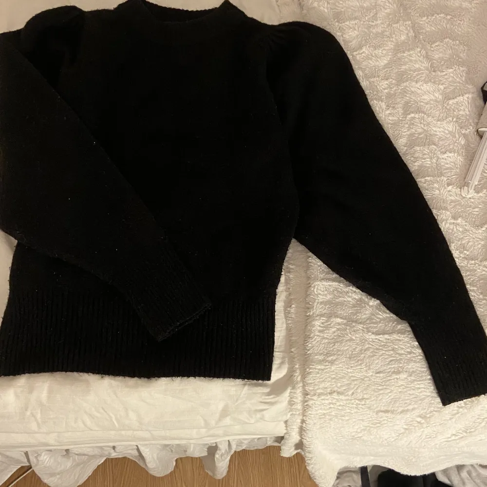 Jag säljer denna snygga svarta stickade tröjan eftersom den aldrig kommit till användning. Den har snygga puffar på båda axlarna, som är en fin extra detalj!❤️. Stickat.