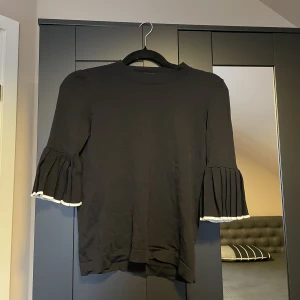 Svart volang tröja - Svart volang tröja med vita detaljer  från cos, passar till allt💕Använd inte köp nu