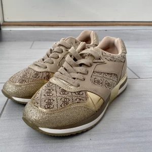 Guess guld glitter skor  - Jättebra skick. Använd endast ett fåtal gånger. Storlek 37. Mycket bekväma sneakers.