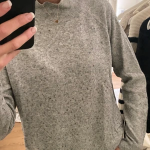 Grå stickad tröja med polo  - Göra stickad tröja med polo krage. Storlek S