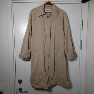 Trenchcoat - Vintagetrenchcoat i klassisk modell och färg, beige. Lite skrynklig på bild efter att ha legat vikt. Storlek 38 och då är den lite oversize i modellen🌿