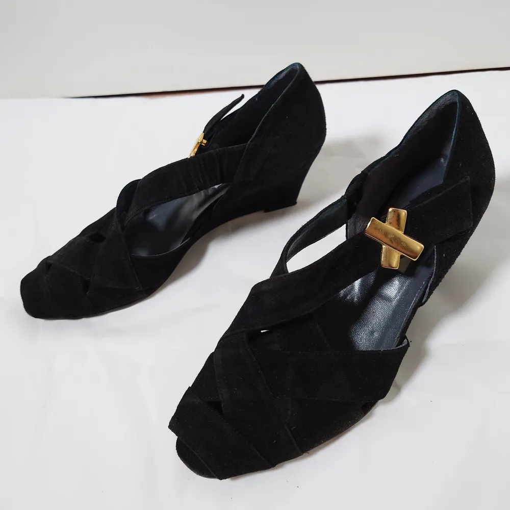 Svarta, äldre skor med tunn, ganska hög klack och gulddetaljer. Innehåller äkta läder🌿. Skor.