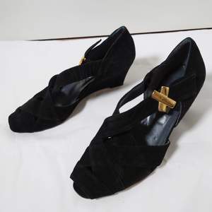 Svarta, äldre skor med tunn, ganska hög klack och gulddetaljer. Innehåller äkta läder🌿