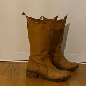 Bruna stövlar i strl 37-38 - Ett par bruna stövlar med 4 cm klack. Osäker på vart de kommer ifrån men fina högklackade stövlar. Men dock några få skador. Köpare står för frakt! 
