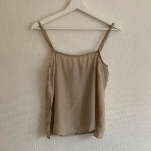 Secondhand topp - Secondhand topp. Lägger sig väldigt fint och är akuten i båda sidorna vid höften 