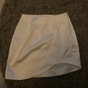 Vit satinkjol - Vit satinkjol från Bershka som går upp lite på ena sidan. Aldrig använd med prislapp kvar. 50kr + frakt