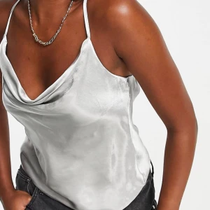 Grå glansig top - Jätte fin grå topp, helt oanvänd med prislappen kvar. Säljer då köpt fel storlek. Skriv för flera bilder 💓 