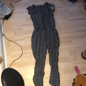 Prickig byxdress  - Svart byxdress med vita prickar Dragkedja fram Säljer pga förliten  