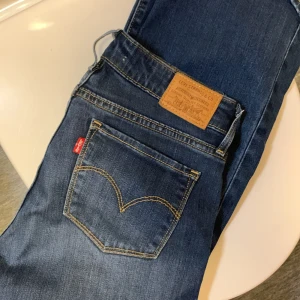 Levis 715 - Säljer mina mörkblå Levis 715 bootcut i storlek 27. Säljes då de ej kommit till användning på något år. I väldigt fint skick, använt dem endast ca 3 gånger 💕 