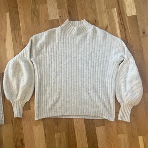 Stickad tröja - Beige stickad tröja med snygga detaljer på ärmarna, köpt från Nelly. strl 36💛