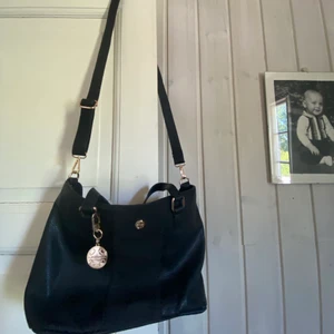 Svart väska  - Säljer denna snygga axelväska från märket Unrika. Aldrig använd, är i bra skick. Lagom stor o lätt att ta med. Köp direkt för 120kr