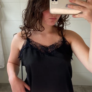 Spets linne - Ett jättefint svart linne med spetsdetaljer. Använt fåtal gånger och i väldigt bra skick. Kontakta mig för fler bilder eller info