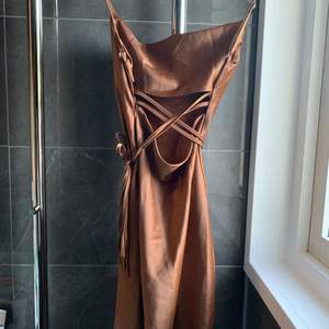 En fin brunrostad klänning, kan knytas hur man vill. Beställde den online men kommer inte ihåg från vilken sida.  OBS, står inte för frakten. 