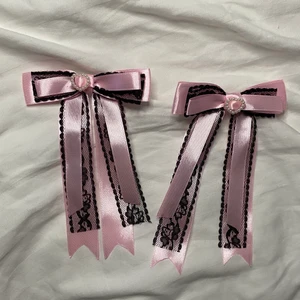 Handgjorda hårrosetter  - Handgjorda hårrosetter i satin och spets! Dekoreras med pärlhjärtan (plast) rosetterna kommer i par och fästs i håret med spännena på baksidan. DMa för betala med swish och billigare frakt 📦 