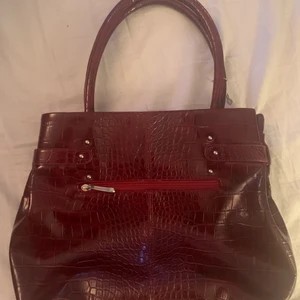 Vintage vädka - (Skriv för mer bilder) en vinröd vintage väska som får plats med mycket i! Fin att styla outfits med, jag använder inte den längre, så det skulle va bra om någon använde den! Ser nästan oanvänd ut! 