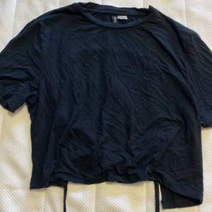 Svart t-shirt i strl L från H&M där det är en öppen rygg och man kan knyta.