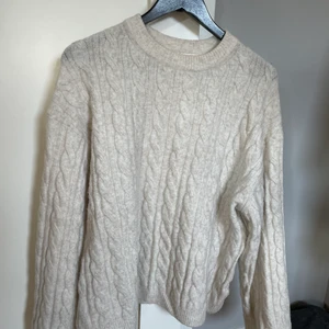 Stickad tröja - Klicka inte köp nu🤗 En beige/crémevit kabelstickad tröja från H&M i strl XS. Den är oversized och väldigt mjuk. Har tyvärr inga bilder med tröjan på. Vet ej nypris men säljer för 100kr