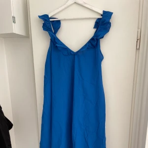 Blå klänning  - Använd en gång. Sista bilden visar klänningen bakifrån. Storlek M men skulle säga som en L i storlek.