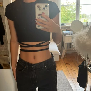 Scary kort tröja - En jättesöt svart och stretchig kort tröja med snören att knyta runt midjan. 