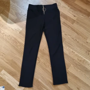 Mjukisbyxor  - Svarta mjukisbyxor med en guld blixtlås  3 fickor, 1 fram och 2 bak  Storlek: M/L 