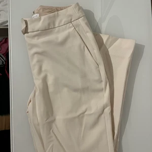 2 par kostymbyxor, topshop och NA-KD - Ett par vita kostymbyxor från Topshop i strl 38, helt oanvända. 200kr. Ett par svarta kostymbyxor från NA-KD, använda fåtal gånger strl 38: 120kr