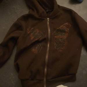 En brun hoodie med fjäril 