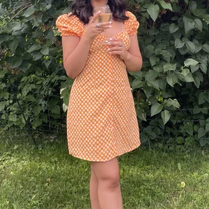 Blommig klänning - Orange blommig klänning från H&M i st 34. Bra skick och perfekt till sommaren!
