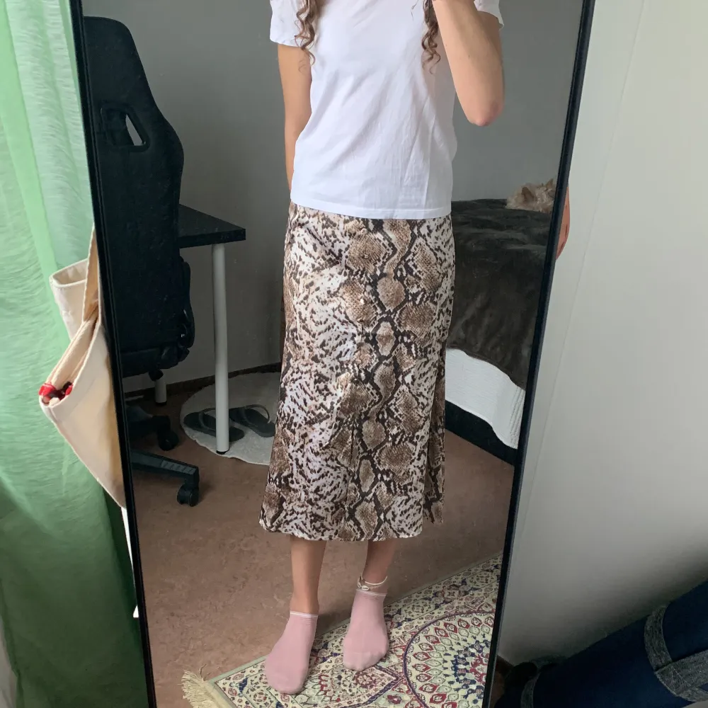 Säljer den här fina satinkjolen med brunt ormmönster på då det är ej min stil längre. Den är använd några gånger. Kjolen har en liten slit på framsidan längst ner och en liten dragkedja på sidan. Saknar en knapp precis ovanför sliten men det märks inte🤎🤍. Hameet.