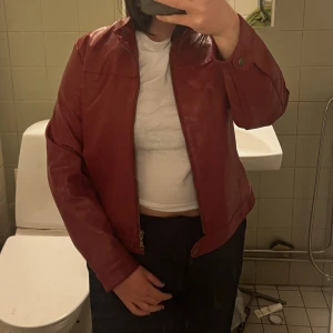 RÖD LÄDERJACKA - Röd läderjacka, äkta läder. Superfint skick, inga skavanker eller dylikt. Märkt som strl: 40/42, upplevs som en M. Kan bäras one size också. 