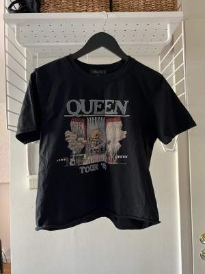 Mörkblå t-shirt med Queen tryck på framsidan från Missguided i stl M. Den är lite croppad.