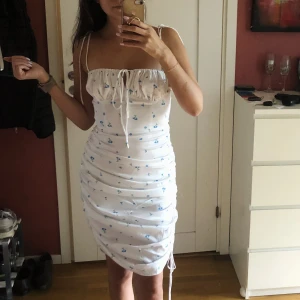 Santorini klänning  - Populär klänning från Adoore - Santorini dress i blank vit. Slutsåld på hemsidan.  Oanvänd med prislapp kvar! Tajt midja med reglerbara band. Superfin men passade inte mig. Nypris 1295kr. 