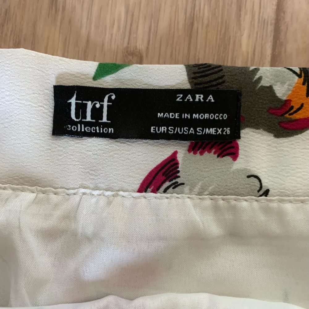 En blommig kjol från märket Zara. Stängs med dragkedja i sidan. Storlek S. Fint skick och sparsamt använd. Material: 100% polyester.. Kjolar.