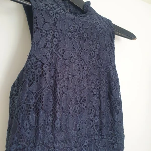 Marinblå byxdress spets - Marinblå byxdress i spets. Endast använd 1 gång. Mjukt tyg på insidan. Fler bilder går att ordna vid intresse. Frakt ingår.