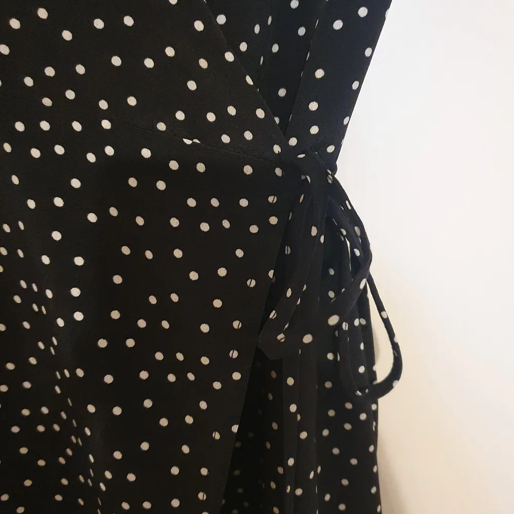 Lång omlott klänning I svart med små vita prickar. Denna klänning faller otroligt snyggt då den har lite tyngd i den. Mycket fint skick! . Klänningar.