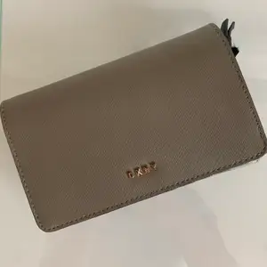 Säljer en mörkgrå/brunaktig plånbok från DKNY. Ordinarie pris är ca 1300 kr, säljer den för 400!!!!! 🤎 
